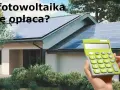 Dom z panelami fotowoltaicznymi na dachu. Kalkulator w dłoni sugeruje, że warto policzyć opłacalność inwestycji w systemy fotowoltaiczne.