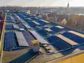 Panele słoneczne na dachu budynku, tworzące instalację, która pozwala na pozyskiwanie energii. To świetny przykład, co to perc-ent energii odnawialnej.