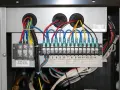 Wiązki przewodów podłączone do listwy zaciskowej, prawdopodobnie moduł wifi do pompy ciepła Panasonic. Widoczne oznaczenia funkcji.
