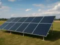Rząd paneli słonecznych na łące, gotowych do produkcji energii. Zastanawiasz się, ile prądu wytwarza panel słoneczny?