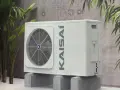 Kaisai 12 kw monoblok, nowoczesna jednostka zewnętrzna klimatyzacji, dyskretnie wkomponowana w otoczenie z roślinnością.