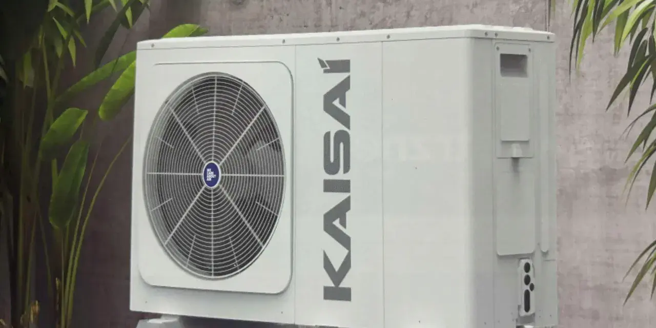 Kaisai 12 kw monoblok, nowoczesna jednostka zewnętrzna klimatyzacji, dyskretnie wkomponowana w otoczenie z roślinnością.