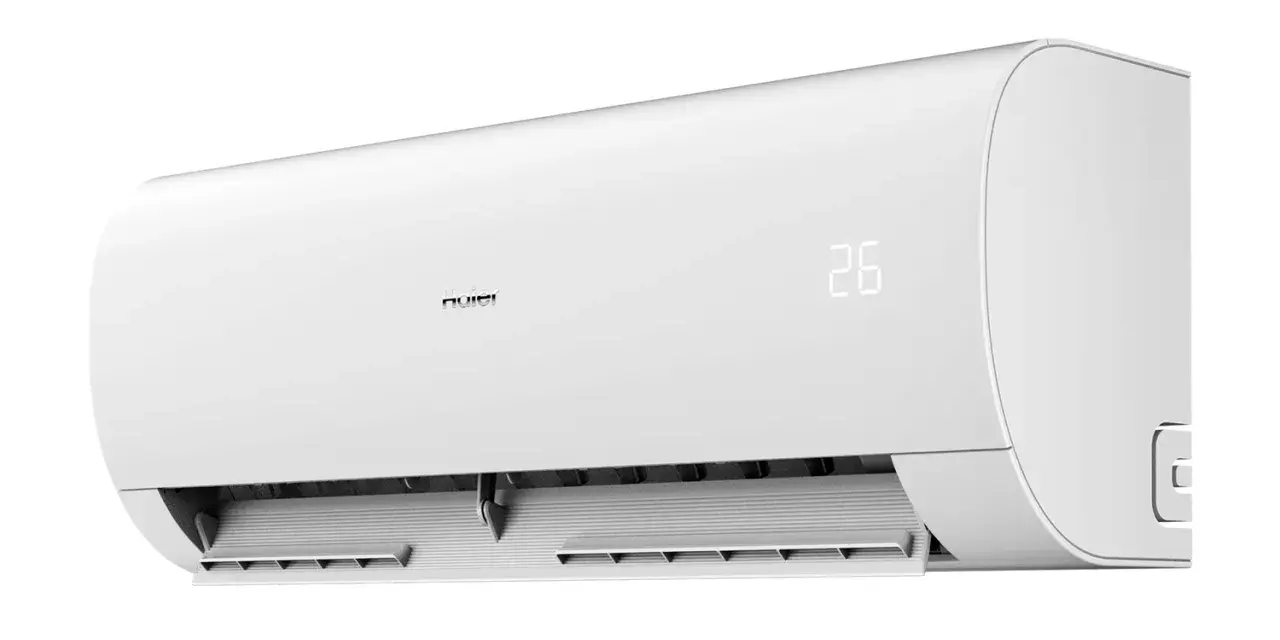 Biała jednostka klimatyzacyjna Haier Pearl Plus z cyfrowym wyświetlaczem temperatury 26 stopni Celsjusza.