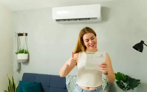 Szczęśliwa kobieta z dokumentem i kciukiem w górę, ciesząca się z dofinansowania do klimatyzacji.