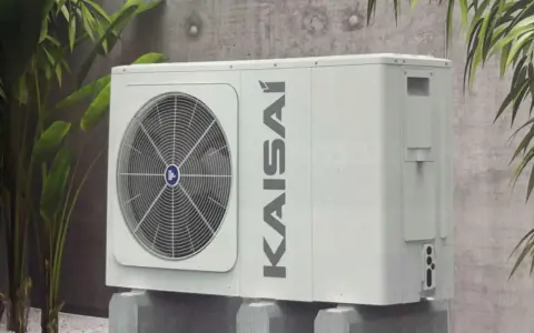 Kaisai 12 kw monoblok, nowoczesna jednostka zewnętrzna klimatyzacji, dyskretnie wkomponowana w otoczenie z roślinnością.