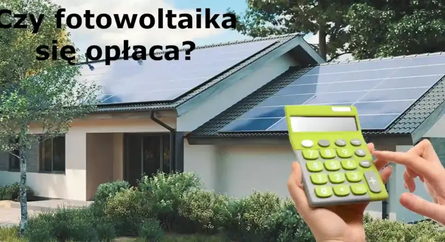 Dom z panelami fotowoltaicznymi na dachu. Kalkulator w dłoni sugeruje, że warto policzyć opłacalność inwestycji w systemy fotowoltaiczne.