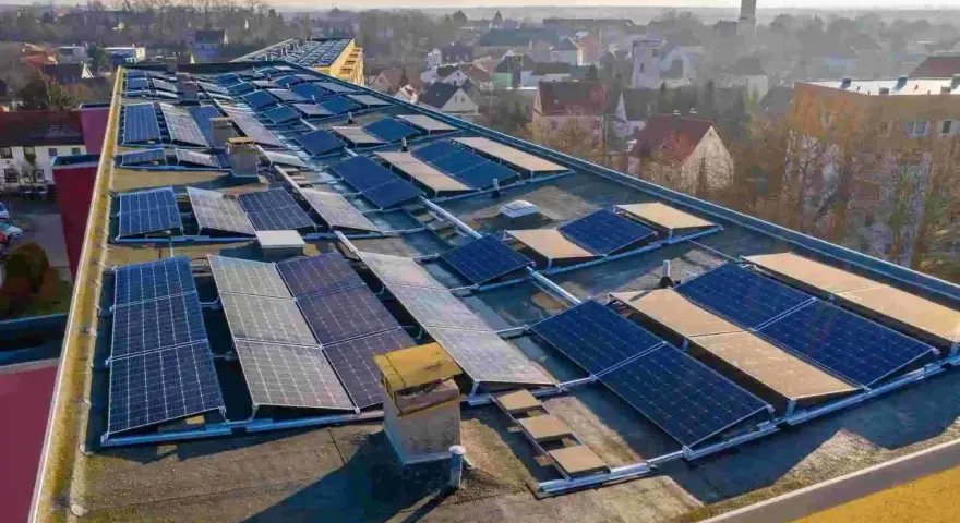 Panele słoneczne na dachu budynku, tworzące instalację, która pozwala na pozyskiwanie energii. To świetny przykład, co to perc-ent energii odnawialnej.