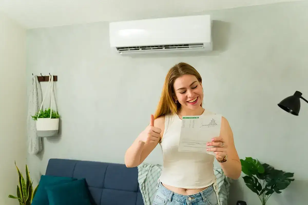 Szczęśliwa kobieta z dokumentem i kciukiem w g&oacute;rę, cieszy się z dofinansowania do klimatyzacji.